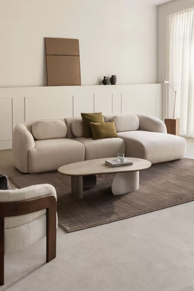 Sofá chaise longue en tejido beige con módulo lateral y cojines, ideal para entender tipos de sofas asimétricos y confortables
